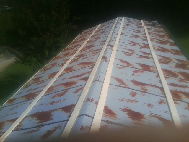 Rusted metal roof panels with new wood purlins before replacement — Storm Damage Roof Repair in Ennice by Roofing Brothers