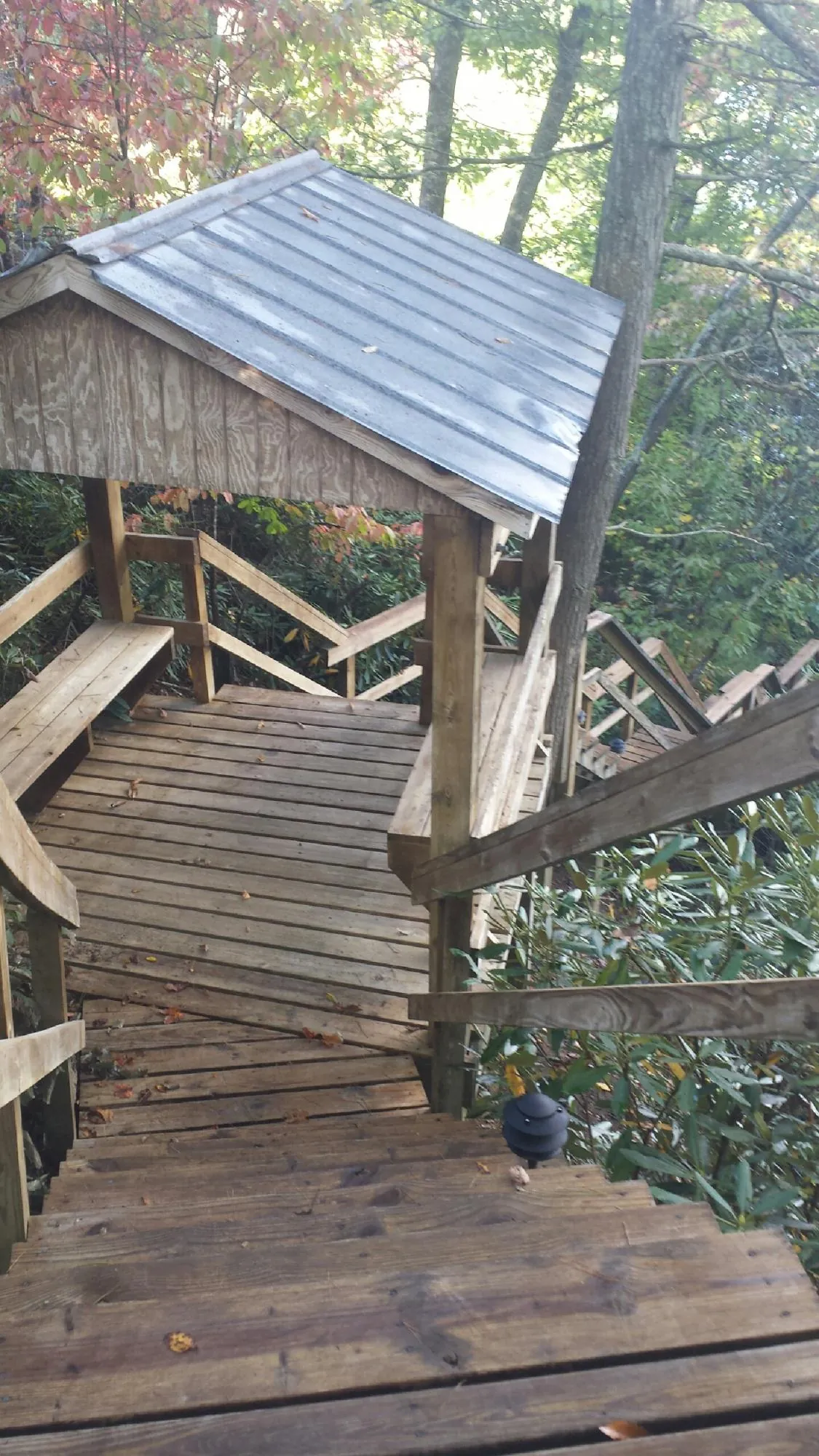Metal roofed shelter over wooden steps on a wooded walkway — Skylight Repair & Installation work by our crew in Ennice