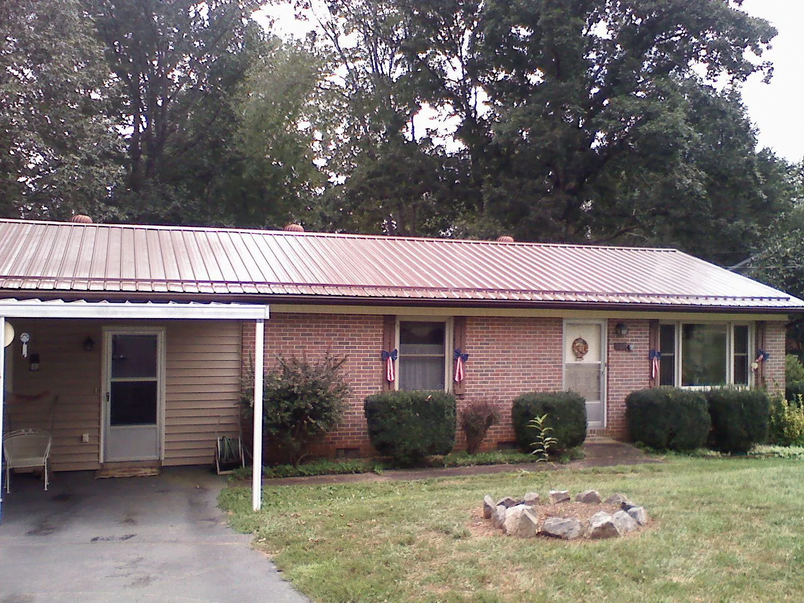 Bronze metal roof and carport on a brick ranch home — Roof Repair work by our crew in Ennice